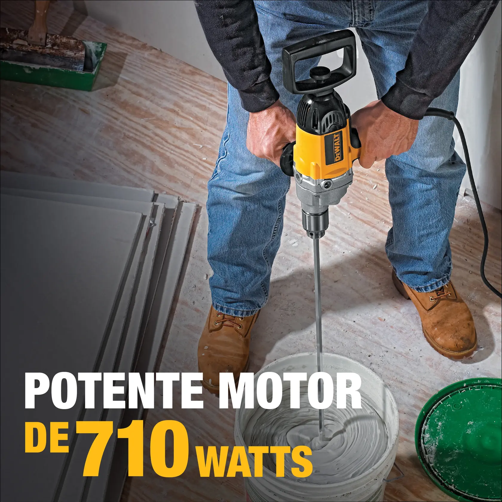 Una persona está usando un taladro DEWALT para mezclar material en un balde en un sitio de construcción. El taladro cuenta con un potente motor de 710 watts, como se destaca en el texto de la imagen.