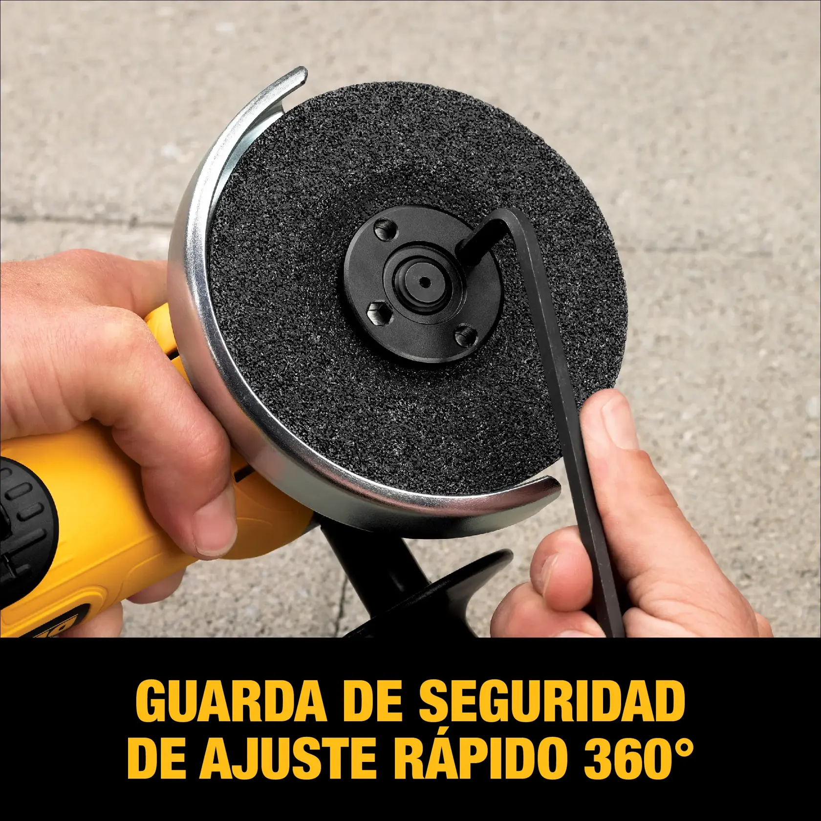 Primer plano de una persona ajustando la guarda de seguridad de una esmeriladora angular DEWALT, destacando la función de ajuste rápido de 360 grados. La herramienta es amarilla y está siendo ajustada con una llave. El texto abajo dice: 'GUARDA DE SEGURIDAD DE AJUSTE RÁPIDO 360°.'
