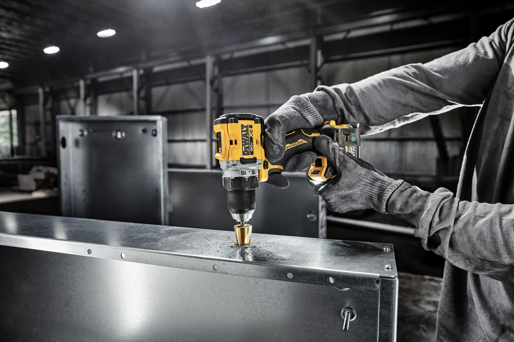Una persona con guantes utiliza un taladro inalámbrico DEWALT para perforar una hoja de metal en un entorno industrial.