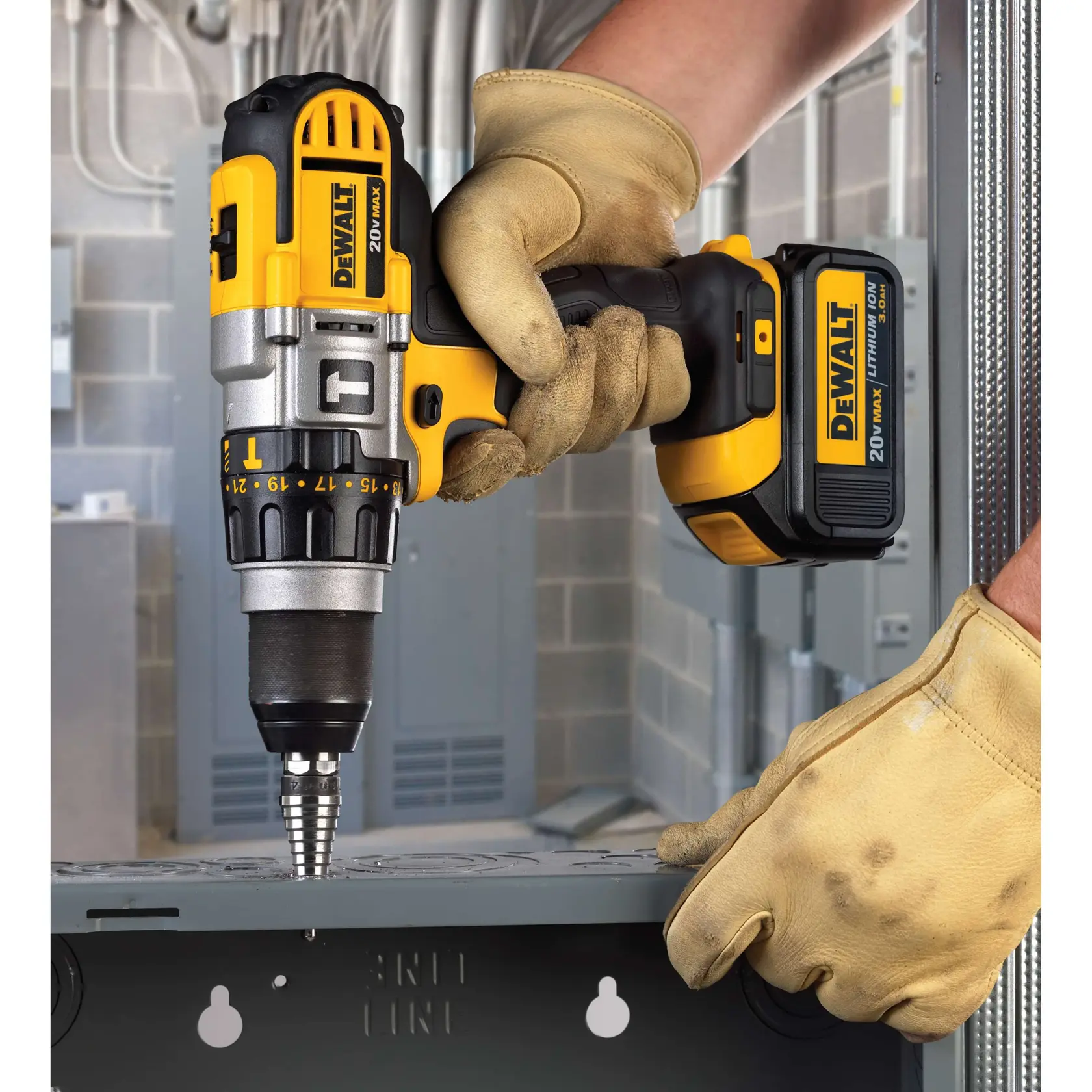 Una persona con guantes de trabajo utiliza un taladro inalámbrico DEWALT 20V Max para perforar una superficie metálica en un entorno industrial.
