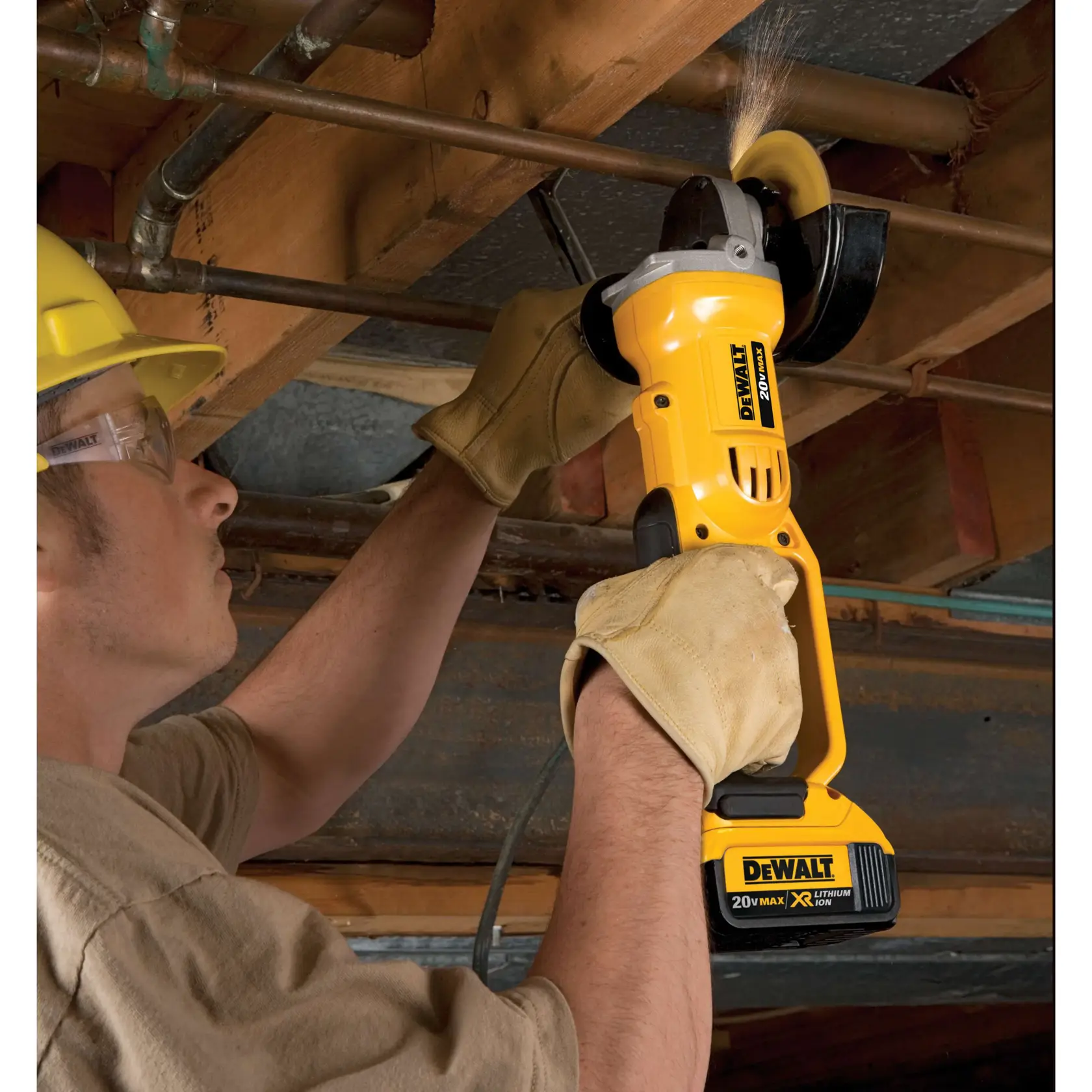 Una persona con guantes está usando una amoladora angular inalámbrica DEWALT para cortar una tubería de metal en un taller o entorno de construcción. La herramienta produce chispas mientras opera.