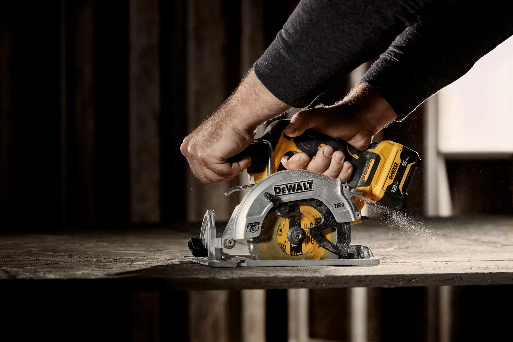 Una persona utiliza una sierra circular inalámbrica DEWALT (modelo DCS512B) para cortar una pieza de madera, con aserrín visible alrededor de la hoja.
