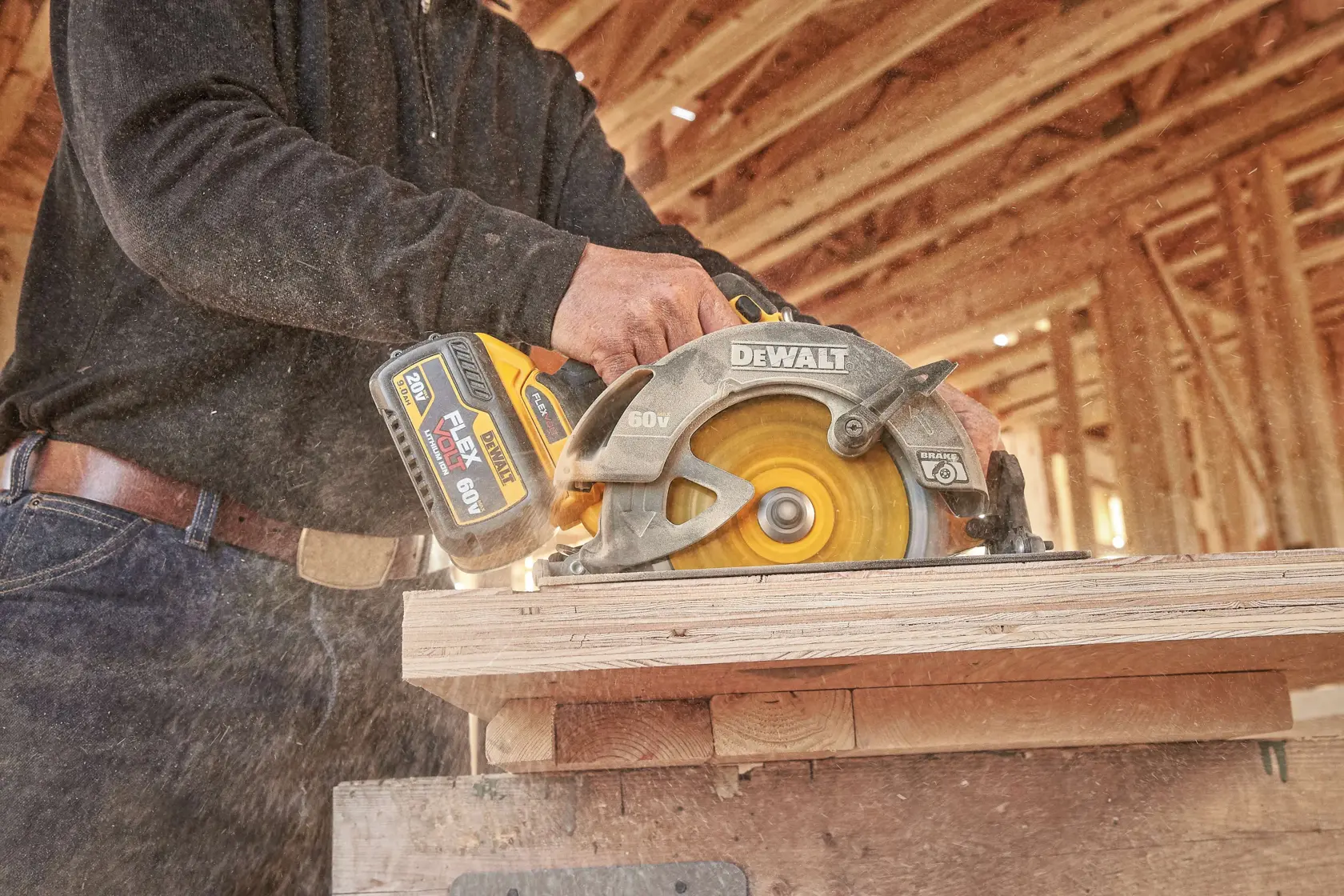 Una sierra circular inalámbrica DEWALT está siendo utilizada para cortar madera en una obra de construcción. La sierra tiene una batería de 60V visible y está generando polvo de madera al operar.