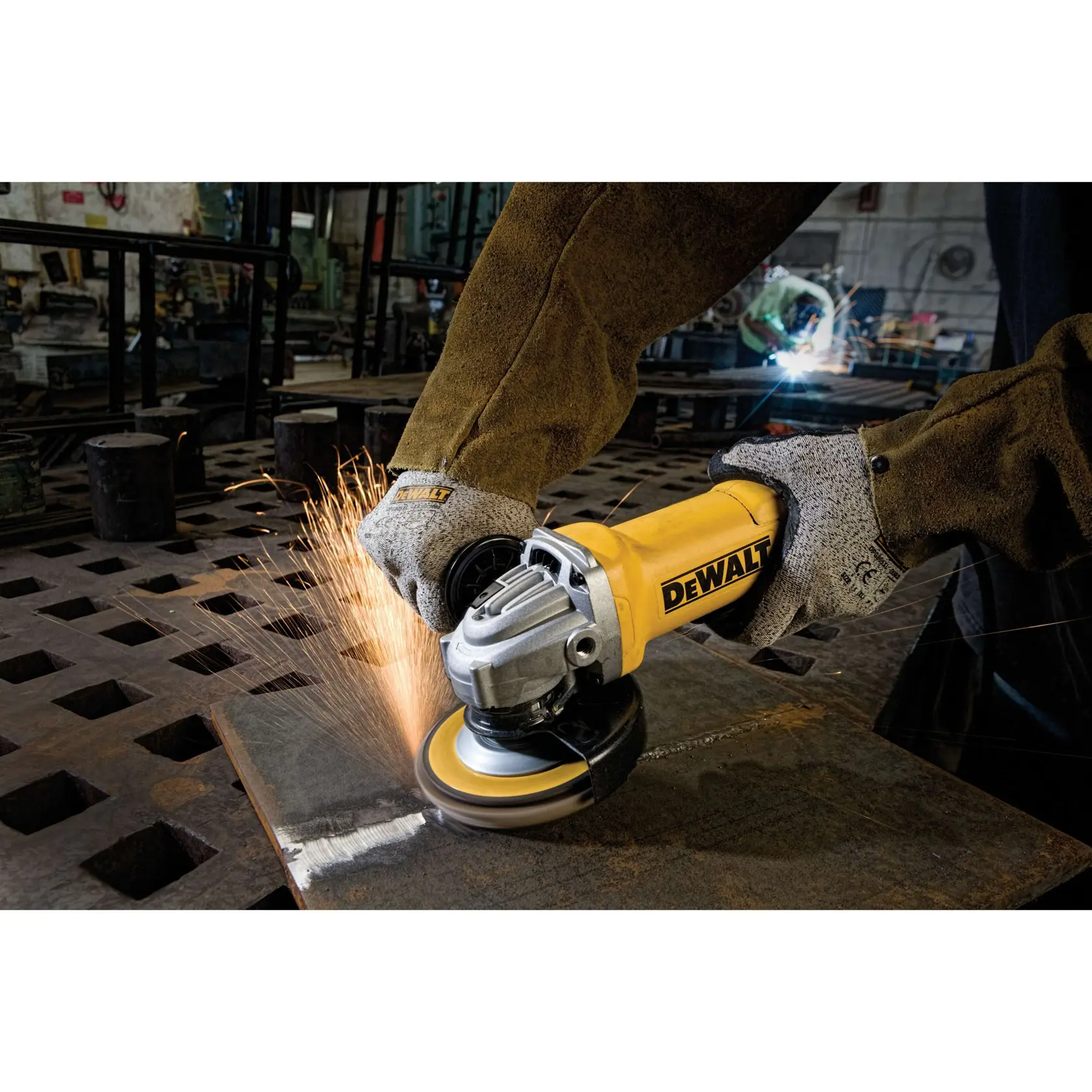 Una persona con guantes de seguridad y chaqueta protectora utiliza una amoladora angular DEWALT para cortar o lijar una pieza de metal, generando chispas en un taller industrial.