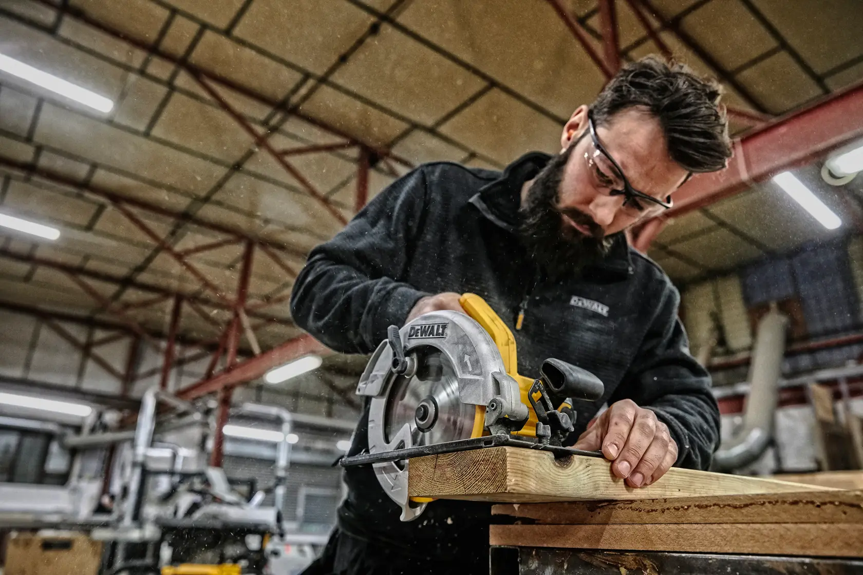 Persona cortando madera con sierra circular DEWALT DWE560 en taller. El rostro está difuminado.